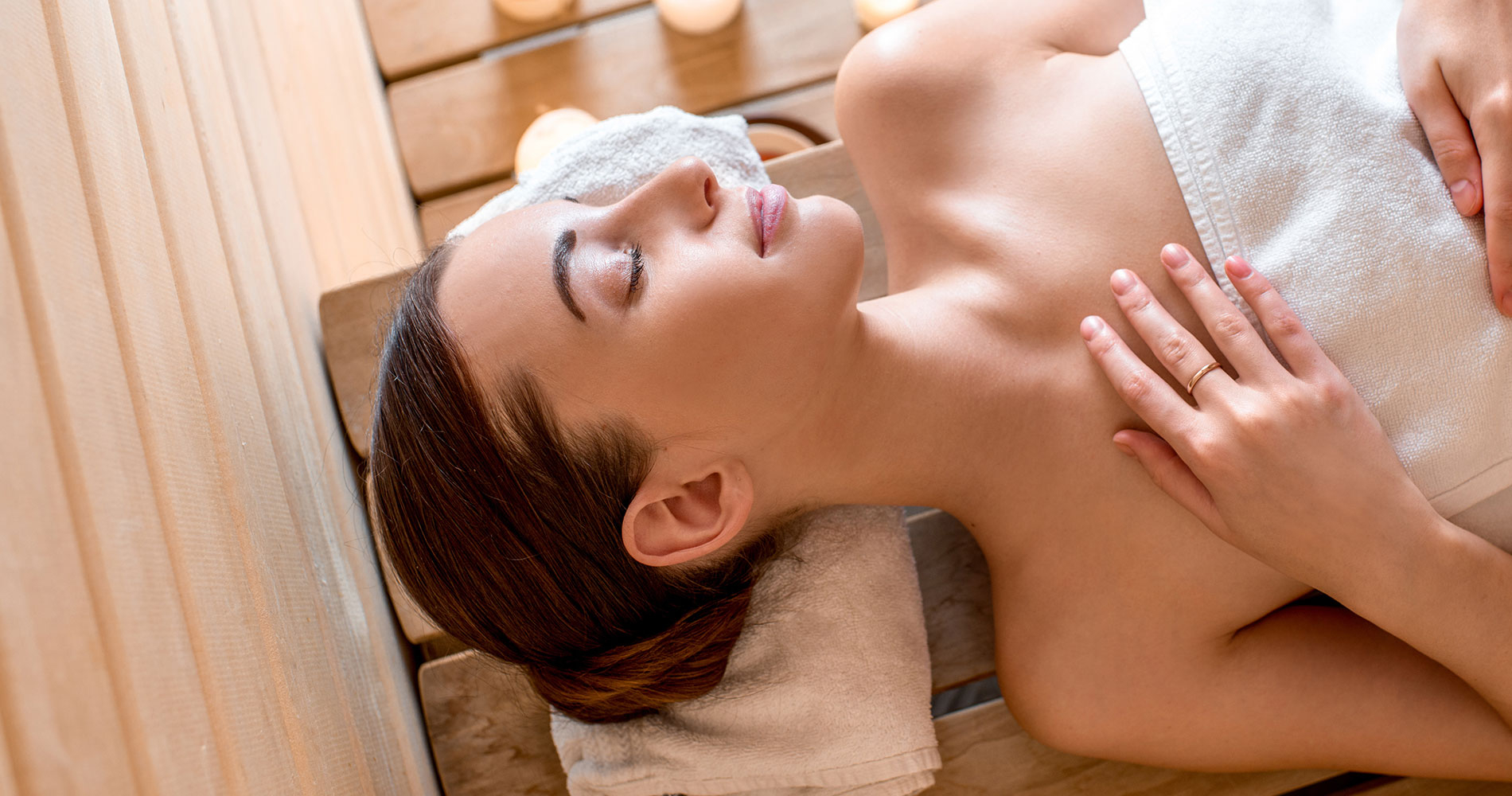Woman relaxing in a wooden sauna